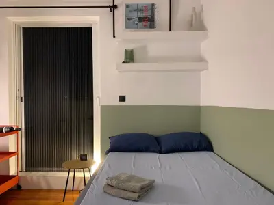 a bed with blue pillows in a room with a window at Athenian Sky in Athens