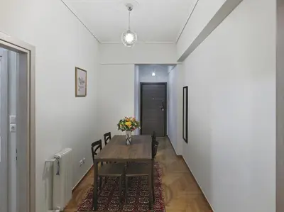 a dining room with a table and a vase of flowers at Comfortable apartment next to Museum and park in Athens