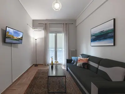 a living room with a couch and a table at Comfortable apartment next to Museum and park in Athens