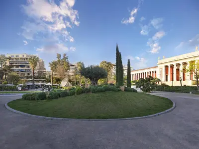 a small circle of grass in front of a building at Comfortable apartment next to Museum and park in Athens