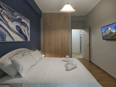 a bedroom with a large white bed with towels on it at Comfortable apartment next to Museum and park in Athens