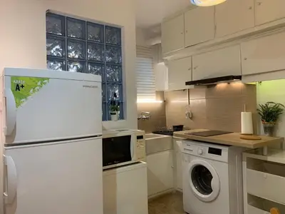 a kitchen with a refrigerator and a washing machine at Chic Urban Living: Apartment in Acropolis-Koukaki in Athens