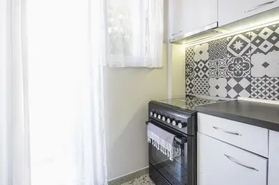 a kitchen with a black stove top oven next to a window at Virona 2nd Floor Greece Apartments in Athens