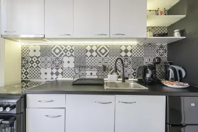 a kitchen with a sink and a tile wall at Virona 2nd Floor Greece Apartments in Athens