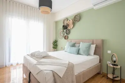 a bedroom with a large bed with white sheets and blue pillows at The Luxury Suite by Cloudkeys in Athens