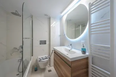 a bathroom with a sink and a shower and a mirror at The Luxury Suite by Cloudkeys in Athens
