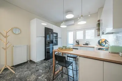 a kitchen with white cabinets and a wooden counter top at The Luxury Suite by Cloudkeys in Athens