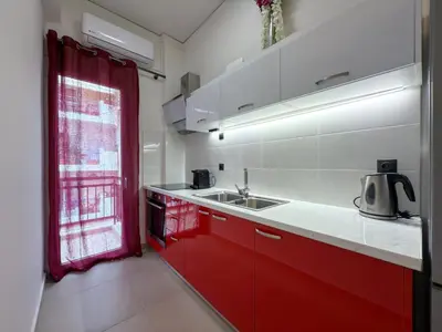 a kitchen with red and white cabinets and a sink at 'Η Ωραία των Αθηνών' A Lux & Cozy Apt in Athens in Athens