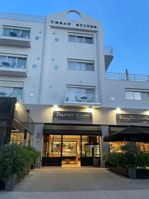 a large white building with a store front at URBAN SUITES ATHENS in Athens
