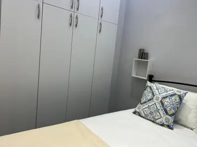 a bedroom with white cabinets and a bed with a pillow at The island studio in Piraeus