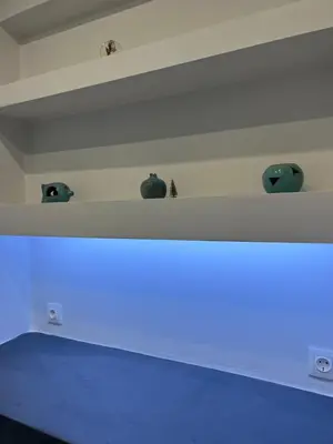 a room with three vases on a wall with blue lights at The island studio in Piraeus