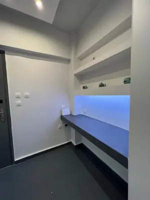a room with a blue bed in a white room at The island studio in Piraeus