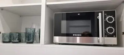 a microwave oven sitting on top of a cabinet at The island studio in Piraeus