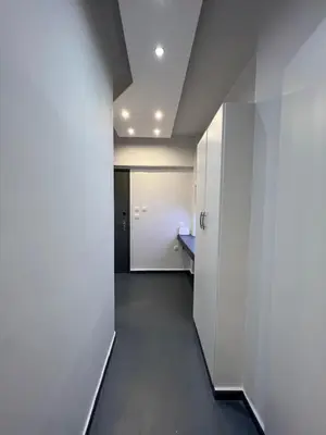 a hallway with white walls and a white door at The island studio in Piraeus