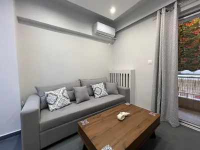 a living room with a couch and a wooden table at The island studio in Piraeus