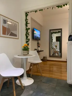a living room with a table and chairs and a mirror at Charming House in Central Athens in Athens