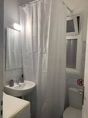 a bathroom with a white shower curtain and a sink at Charming House in Central Athens in Athens