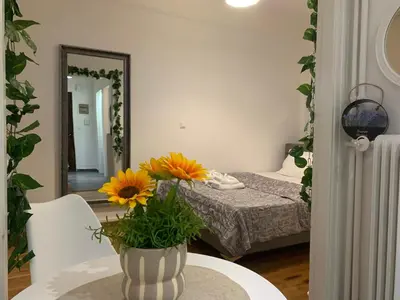 a bedroom with a bed and a vase with flowers on a table at Charming House in Central Athens in Athens
