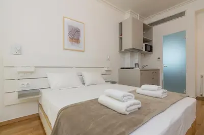 a bedroom with a large white bed with towels on it at Exclusive Studio in Athens A in Athens