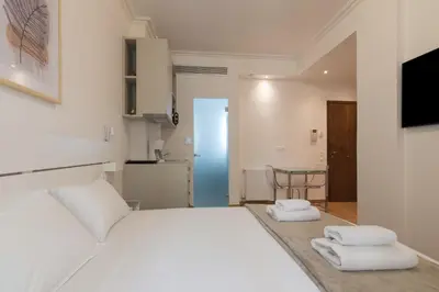 a bedroom with a white bed and a table at Exclusive Studio in Athens A in Athens