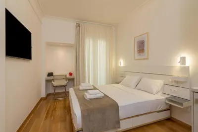 a white bedroom with a large bed and a desk at Exclusive Studio in Athens A in Athens