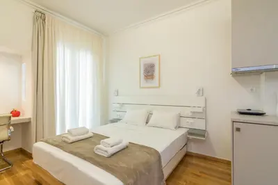 a white bedroom with a bed with two towels on it at Exclusive Studio in Athens A in Athens