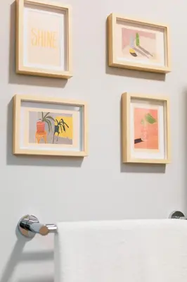 a bathroom with three framed pictures on a wall at Vivid Stays Athens in Athens