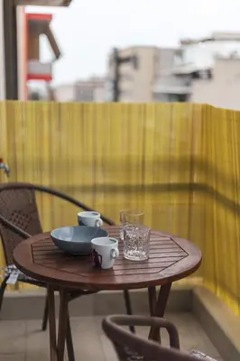 a wooden table with a bowl and cups on it at Vivid Stays Athens in Athens