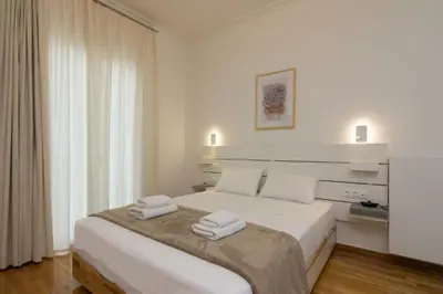 a white bedroom with a bed with two towels on it at Elegant Studio In Athens B in Athens