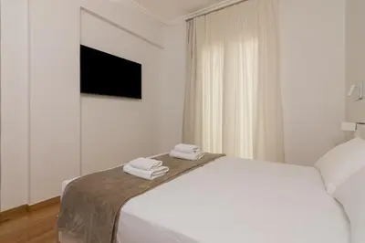 a white bedroom with a bed with towels on it at Elegant Studio In Athens B in Athens