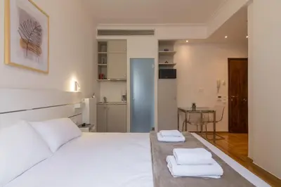 a bedroom with a large white bed with towels on it at Elegant Studio In Athens B in Athens