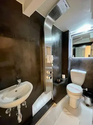 a bathroom with a sink and a toilet at LIVING IN A CAVE UNDER ACROPOLIS in Athens