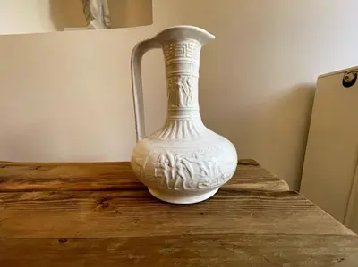 a white vase sitting on top of a wooden table at LIVING IN A CAVE UNDER ACROPOLIS in Athens