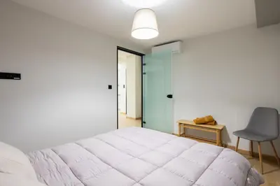a bedroom with a large white bed and a chair at Bright 2BDR Apartment Downtown Exarcheia! in Athens