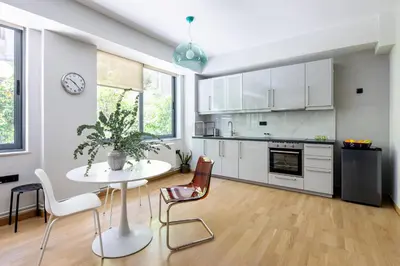 a kitchen with white cabinets and a table and chairs at Bright 2BDR Apartment Downtown Exarcheia! in Athens