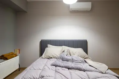 an unmade bed with a blanket on it in a bedroom at Bright 2BDR Apartment Downtown Exarcheia! in Athens