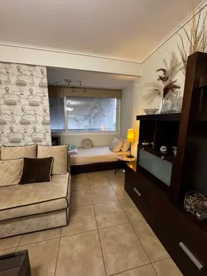 a living room with a couch and a window at Hill View Apartment near Acropolis in Athens