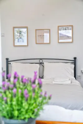 a bedroom with a bed and a vase of purple flowers at Lux Garden Apartment near Acropolis in the heart of Athens in Athens