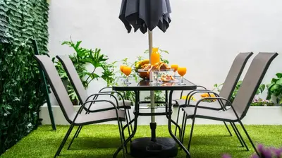 a table with chairs and an umbrella with fruit on it at Lux Garden Apartment near Acropolis in the heart of Athens in Athens