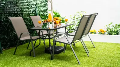 a table and chairs on grass with oranges on it at Lux Garden Apartment near Acropolis in the heart of Athens in Athens