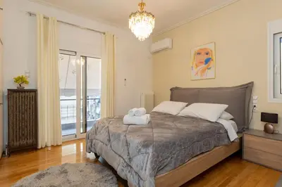 a bedroom with a large bed and a chandelier at Attiki - Appartment in Athens
