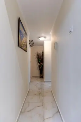 a hallway with white walls and a painting on the wall at Attiki - Appartment in Athens