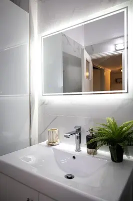 a bathroom with a white sink and a mirror at Attiki - Appartment in Athens