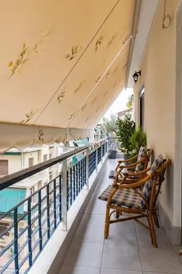 a balcony with two chairs sitting on a balcony at Attiki - Appartment in Athens