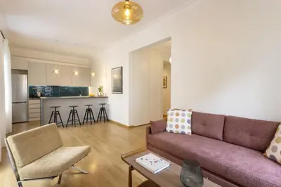 a living room with a couch and a table at Versi2- Stylish 1BR pays homage to timeless charm in Athens