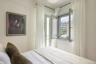 a bedroom with a bed and a window at Versi2- Stylish 1BR pays homage to timeless charm in Athens