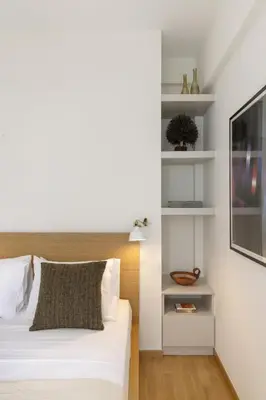 a bedroom with a bed and a tv on a wall at Versi2- Stylish 1BR pays homage to timeless charm in Athens