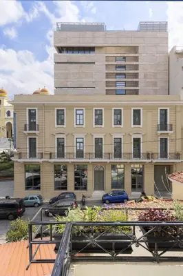 a large building with cars parked in front of it at Versi2- Stylish 1BR pays homage to timeless charm in Athens