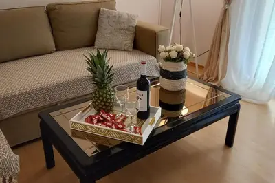 a coffee table with a bottle of wine and a pineapple at Tiny Treasure Apartment in Athens