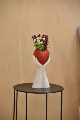 a vase filled with flowers sitting on a table at Tiny Treasure Apartment in Athens
